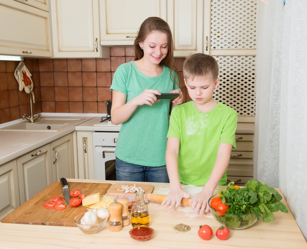 Children cooking homemade pizza at home kitchen. Making food photo.